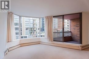 Vancouver apartment for rent - A large, empty room with a view of a cityscape through large windows.