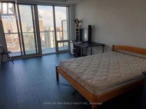 Toronto (Church-Yonge Corridor) condo for rent - A bedroom with a large bed and a balcony overlooking the city.