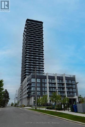 Toronto (Islington-City Centre West) condo for rent - A tall building with a curved facade stands next to a shorter building with a flat facade.