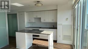 Toronto (University) condo for rent - A kitchen with white cabinets and a black countertop.
