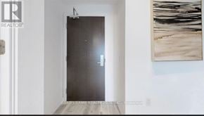Toronto (Moss Park) condo for rent - A modern interior with a dark door and a painting on the wall.