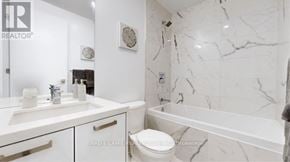 Toronto (Moss Park) condo for rent - A white bathroom with marble tiles and a toilet.