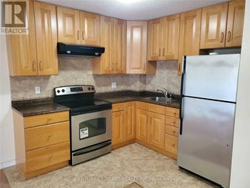 Toronto (Clairlea-Birchmount) townhouse for rent - A kitchen with wooden cabinets and a stainless steel refrigerator.