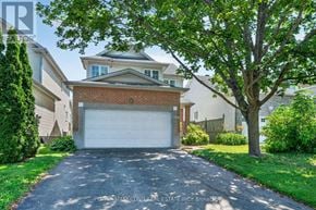 Ottawa apartment for rent - A residential house with a driveway and a tree in front.