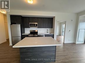 Clarington (Bowmanville) condo for rent - A kitchen with a white counter top and black cabinets.