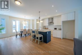 Orillia townhouse for rent - A well-lit kitchen and dining area with wooden floors and white walls.