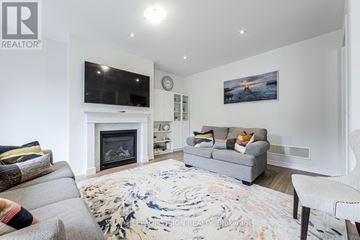 Whitby (Rolling Acres) apartment for rent - A living room with a grey couch, a fireplace, and a painting on the wall.