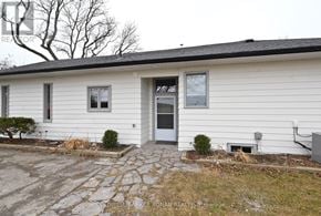 New Tecumseth multi-family for rent - A white house with a grey door and a small front yard.