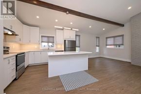 New Tecumseth multi-family for rent - A modern kitchen with white cabinets and a central island.