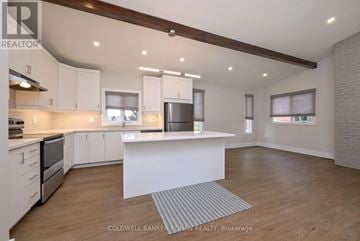 New Tecumseth duplex for rent - A modern kitchen with white cabinets and a central island.