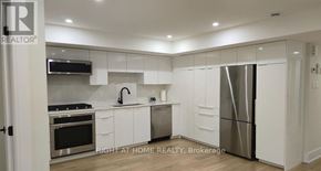 Ottawa apartment for rent - A modern kitchen with white cabinets and stainless steel appliances.