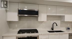 Ottawa apartment for rent - A modern kitchen with a stove top oven and a microwave above it.