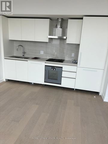 Toronto (Annex) condo for rent - A kitchen with white cabinets and a wooden floor.