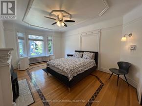 Toronto (Palmerston-Little Italy) apartment for rent - A bedroom with a bed, chair, and ceiling fan.