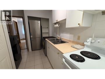 Vancouver apartment for rent - A kitchen with white appliances and a stove top oven.