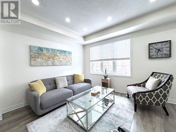 Milton (Fo Ford) townhouse for rent - A living room with a grey couch, a glass coffee table, and a painting on the wall.