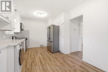 St. Catharines (Glendale/Glenridge) apartment for rent - A kitchen with white cabinets and a wooden floor.