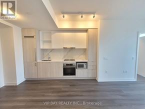 Toronto (Waterfront Communities) condo for rent - A kitchen with a stove top oven and microwave built into the cabinetry.
