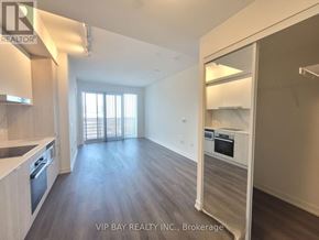 Toronto (Waterfront Communities) condo for rent - A spacious kitchen and living area with wood flooring and white walls.