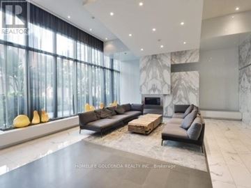 Toronto (Waterfront Communities) condo for rent - A spacious living room with a black sofa set and a marble fireplace.