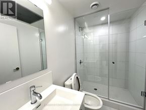 Toronto (Kensington-Chinatown) condo for rent - A white bathroom with a glass shower door.