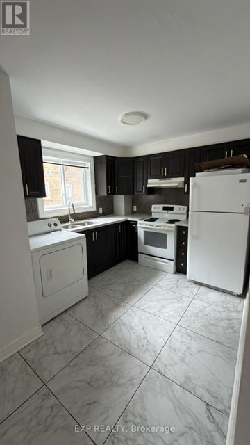 Toronto (Cliffcrest) fourplex for rent - A kitchen with white appliances and black cabinets.