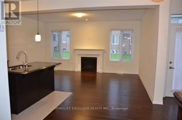 Aurora apartment for rent - A spacious living room with a fireplace and a kitchen area with a sink and countertop.