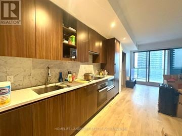 Toronto (Bayview Village) condo for rent - A kitchen with wooden cabinets and a marble countertop.