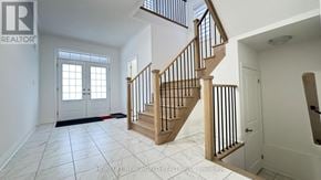 East Gwillimbury (Holland Landing) apartment for rent - A spacious hallway with a wooden staircase and white walls.