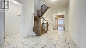 East Gwillimbury (Holland Landing) apartment for rent - A spacious hallway with a wooden staircase and white walls.