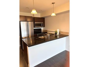 Langley apartment for rent - A kitchen with a black countertop and stainless steel appliances.