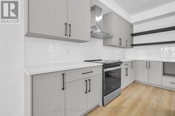 London South (South W) house for rent - A modern kitchen with white cabinets and stainless steel appliances.