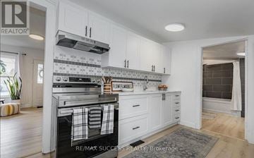 Woodstock (Woodstock - South) apartment for rent - A kitchen with white cabinets and a black and white tiled backsplash.