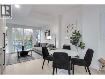 North Vancouver apartment for rent - A living room with a white couch, a coffee table, and a dining table with chairs.