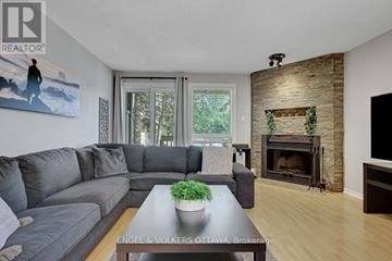 Ottawa townhouse for rent - A living room with a grey couch and a fireplace.
