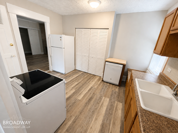 Louisville apartment for rent - A kitchen with a white fridge, a black dishwasher, and a white sink.