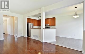 Mississauga (Churchill Meadows) apartment for rent - A spacious kitchen with wooden cabinets and a black refrigerator.