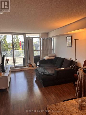Toronto (Bayview Village) condo for rent - A living room with a couch, a chair, and a table with a glass on it.
