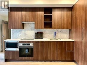 Toronto (Bayview Village) condo for rent - A kitchen with wooden cabinets and a microwave oven.
