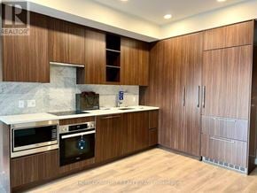 Toronto (Bayview Village) condo for rent - A kitchen with wooden cabinets and a marble countertop.