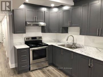 Toronto (Long Branch) apartment for rent - A kitchen with dark cabinets and a stove top oven.