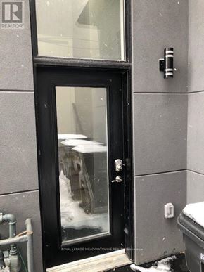 Toronto (Long Branch) apartment for rent - A black door with a glass window and a sign that says "ROYALLEGUE Meadowvine Realty".