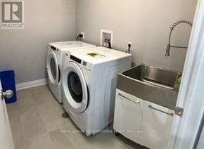Toronto (Long Branch) apartment for rent - A laundry room with a washer and dryer and a metal sink.