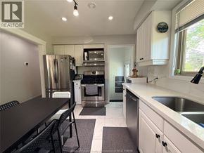 Windsor apartment for rent - A kitchen with white cabinets and a black table.