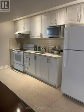 Brampton (Sandringham-Wellington) apartment for rent - A white kitchen with a refrigerator, microwave, and oven.