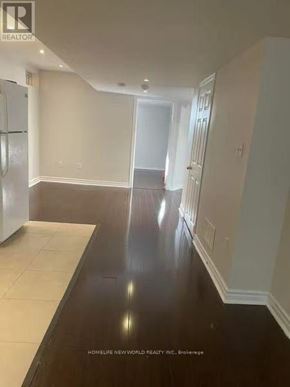 Brampton (Sandringham-Wellington) apartment for rent - A spacious room with a white fridge and a wooden floor.