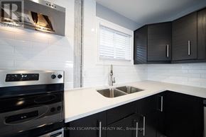 Cambridge apartment for rent - A modern kitchen with a stove, sink, and cabinets.