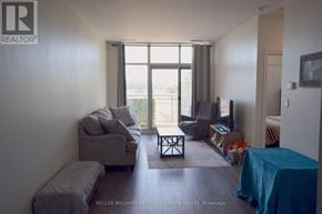 Toronto (Thorncliffe Park) condo for rent - A living room with a grey couch and a blue tablecloth.