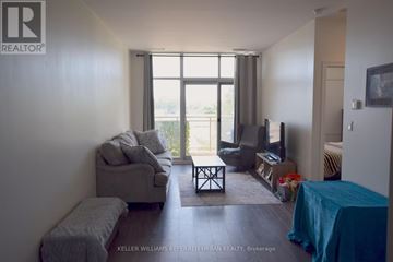 Toronto (Thorncliffe Park) condo for rent - A living room with a grey couch and a blue tablecloth.