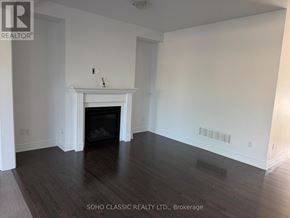 East Gwillimbury (Sharon) apartment for rent - A large, empty room with a fireplace and wooden floors.